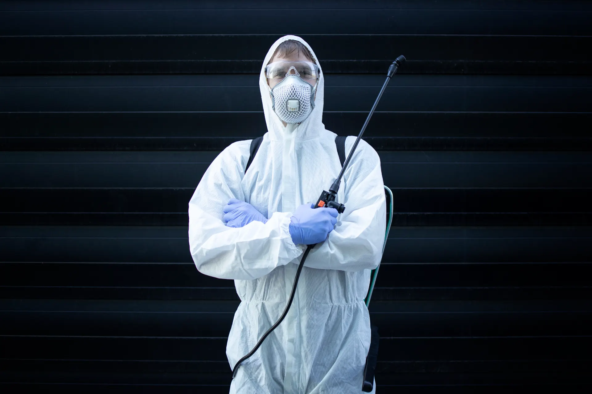Exterminateur en combinaison de protection traitant une cuisine